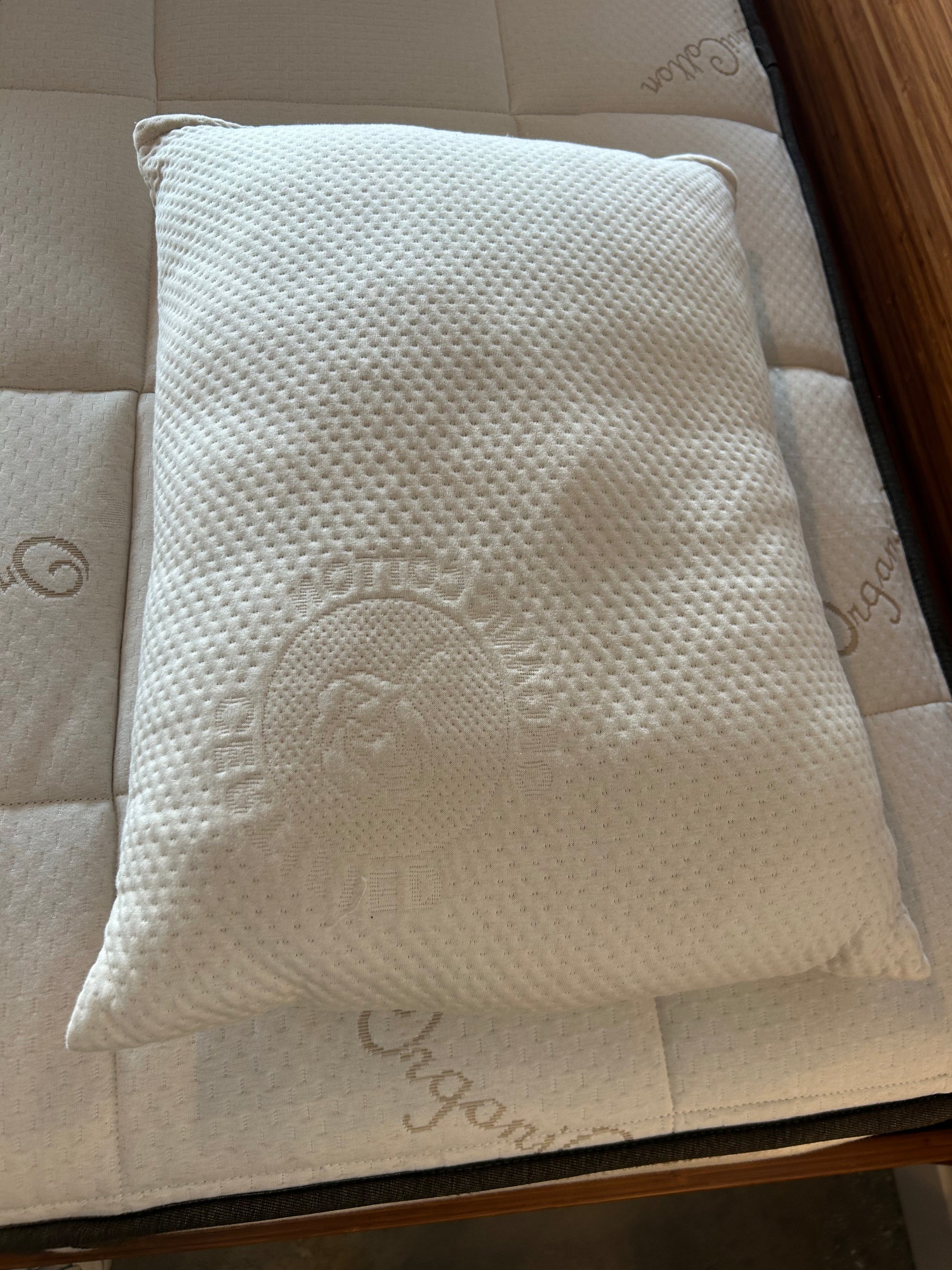 White pillow with a brand logo on a textured surface