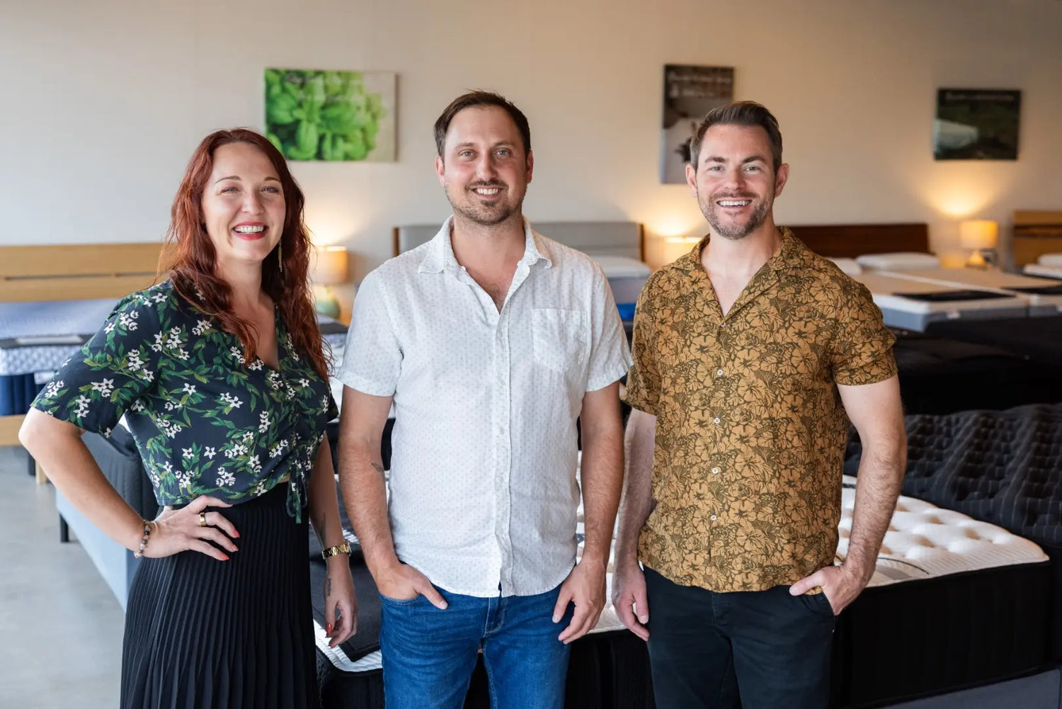 Three people standing in a furnished room.